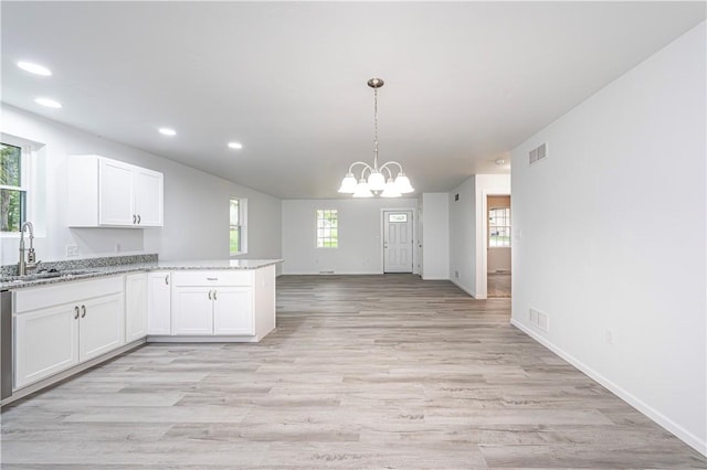 kitchen featuring recessed lighting, visible vents, a sink, white cabinetry, and a peninsula