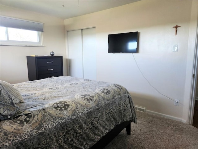 bedroom with baseboards, carpet flooring, a closet, and visible vents