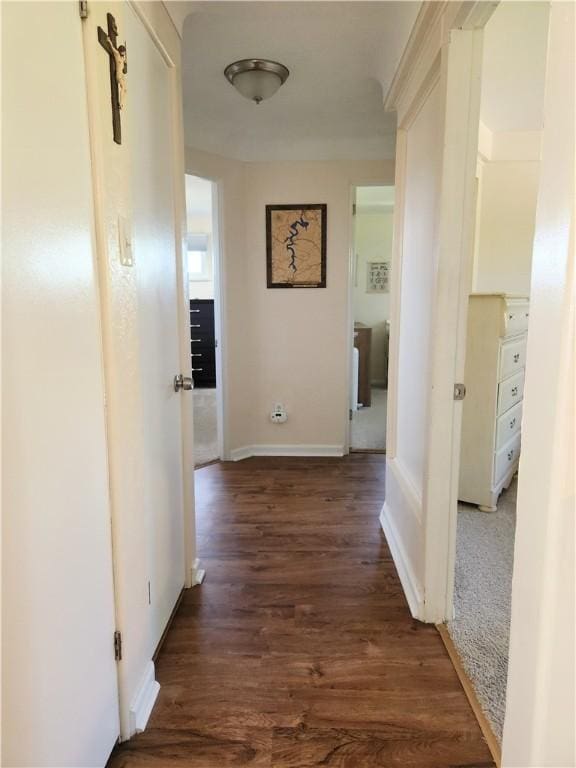 hallway featuring baseboards and wood finished floors