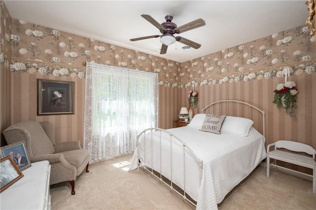 carpeted bedroom with a ceiling fan, wallpapered walls, and visible vents