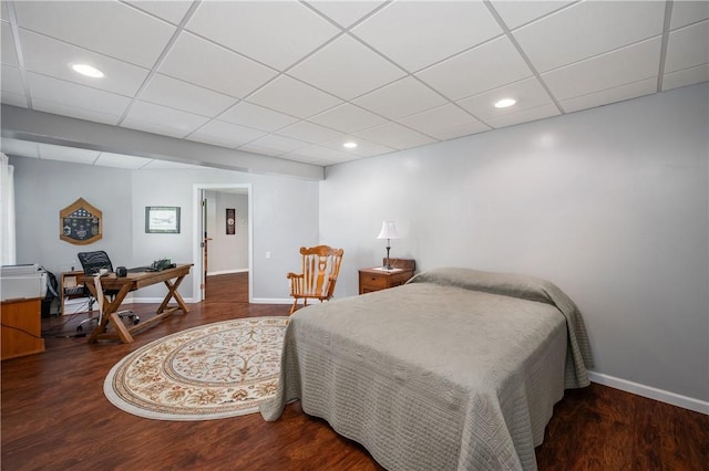 bedroom with a drop ceiling, wood finished floors, baseboards, and recessed lighting