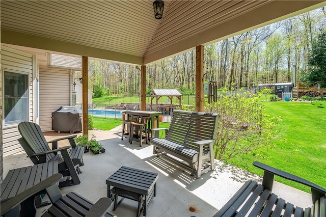 view of patio with grilling area, a fenced in pool, and fence