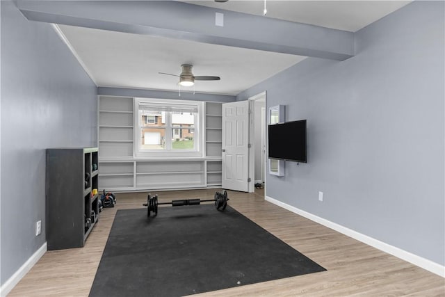 workout area featuring ceiling fan, baseboards, and wood finished floors