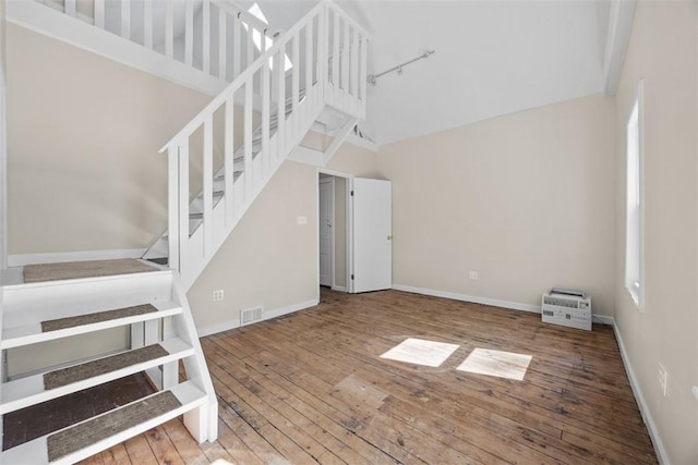 5611 Wickliff St, Lawrenceville, PA 15201 - stairway with baseboards, high vaulted ceiling, visible vents, and hardwood / wood-style flooring