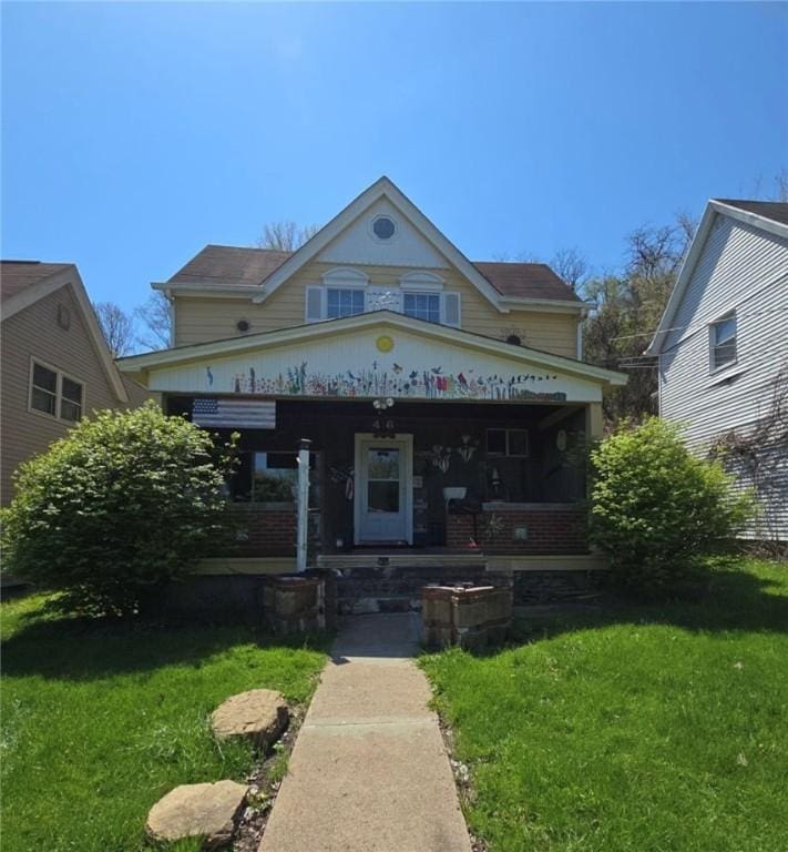 view of front of house with covered porch and a front lawn