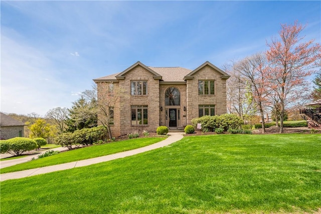traditional home featuring a front lawn and brick siding