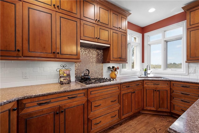 kitchen featuring a sink, brown cabinetry, stainless steel gas cooktop, and dark wood finished floors