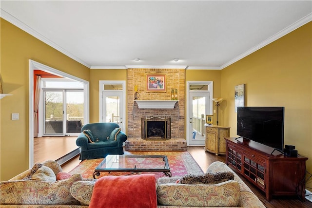 living area with crown molding, a healthy amount of sunlight, and wood finished floors