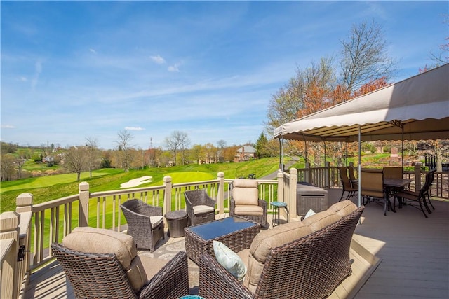 wooden deck featuring a gazebo, outdoor dining space, and a lawn