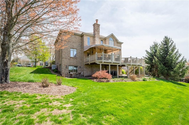 back of property with a chimney, a deck, cooling unit, and a lawn