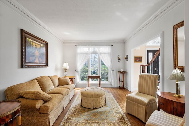 living area featuring ornamental molding and wood finished floors