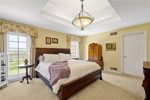 bedroom with baseboards, a raised ceiling, visible vents, and light colored carpet
