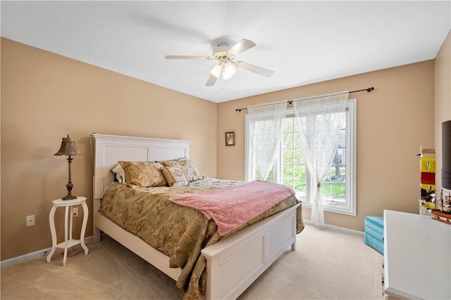 bedroom with baseboards, ceiling fan, and light colored carpet