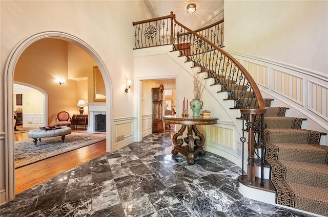 1609 Blackburn Heights Dr, Franklin Park, PA 15143 - foyer entrance featuring marble finish floor, wainscoting, a decorative wall, a towering ceiling, and arched walkways