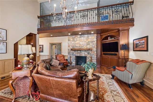 1609 Blackburn Heights Dr, Franklin Park, PA 15143 - living area with built in features, a wainscoted wall, a towering ceiling, a fireplace, and wood finished floors