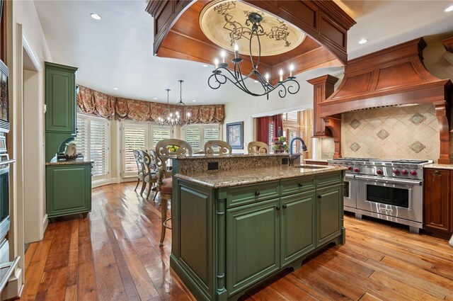 1609 Blackburn Heights Dr, Franklin Park, PA 15143 - kitchen featuring a sink, green cabinetry, a kitchen bar, a notable chandelier, and luxury range