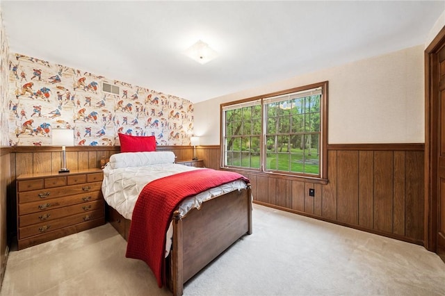 bedroom featuring wainscoting, wooden walls, carpet, and visible vents