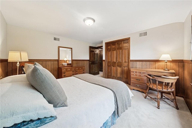 bedroom with a wainscoted wall, visible vents, and wood walls