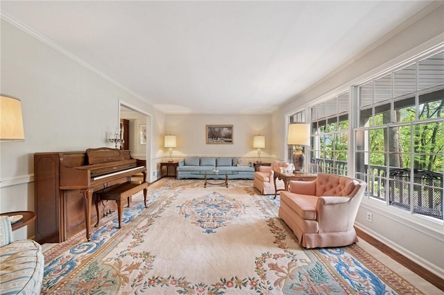 living area featuring baseboards, ornamental molding, and wood finished floors