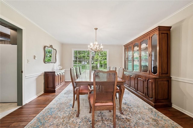 dining area featuring an inviting chandelier, dark wood-style flooring, baseboards, and ornamental molding