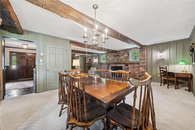 carpeted dining room featuring a chandelier, beam ceiling, wooden walls, and a textured ceiling