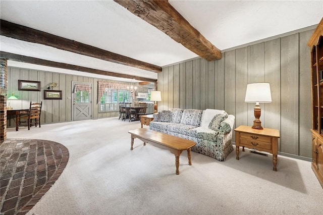 living area with wooden walls, carpet flooring, and beam ceiling