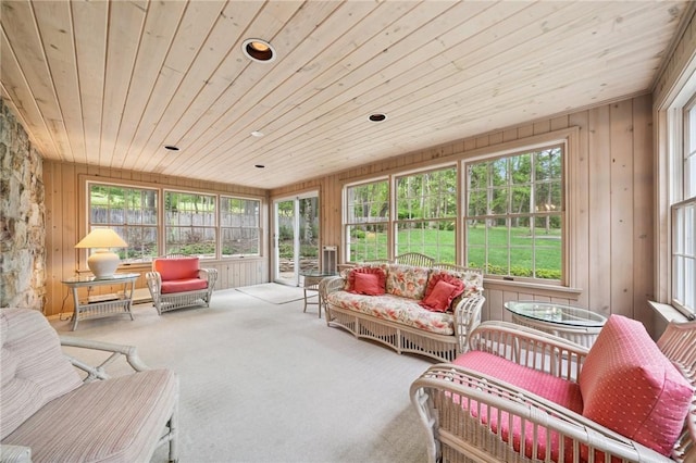 sunroom featuring a healthy amount of sunlight, wood walls, and wooden ceiling