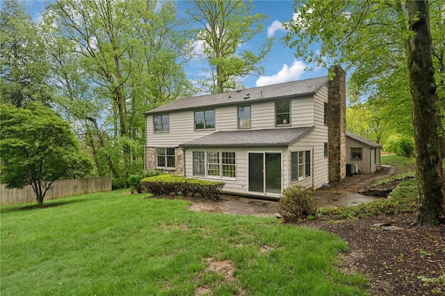 back of property with a yard, fence, a chimney, and central AC unit
