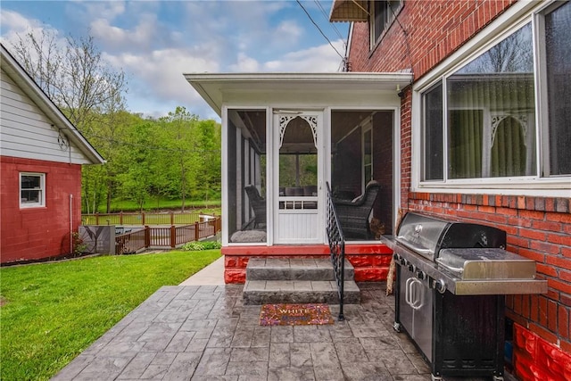 property entrance featuring a yard, brick siding, and a patio