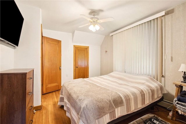 bedroom featuring light wood-type flooring, a baseboard radiator, and ceiling fan