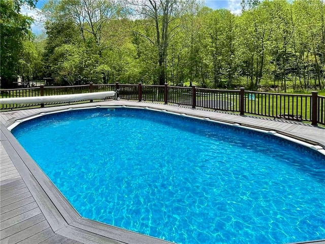 view of swimming pool with a deck and a fenced in pool