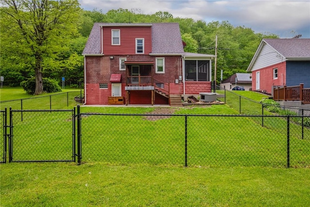 rear view of property with a gate, central air condition unit, brick siding, a fenced backyard, and a sunroom