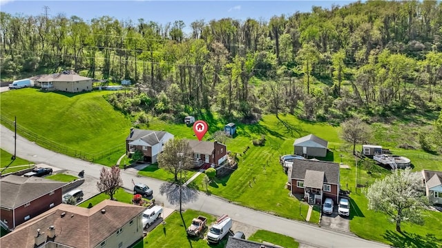 drone / aerial view featuring a wooded view and a residential view