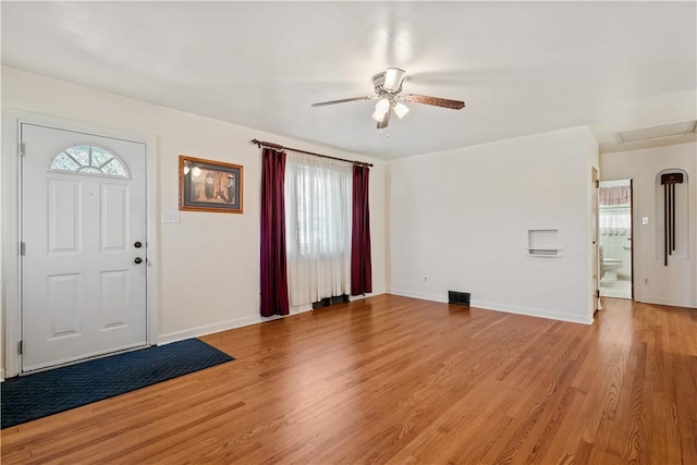 foyer featuring ceiling fan, baseboards, light wood finished floors, and visible vents