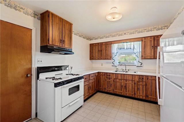 kitchen featuring brown cabinets, white appliances, a sink, and under cabinet range hood
