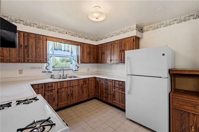 kitchen with light countertops, a sink, and white appliances