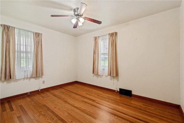 unfurnished room with plenty of natural light, baseboards, light wood-type flooring, and visible vents