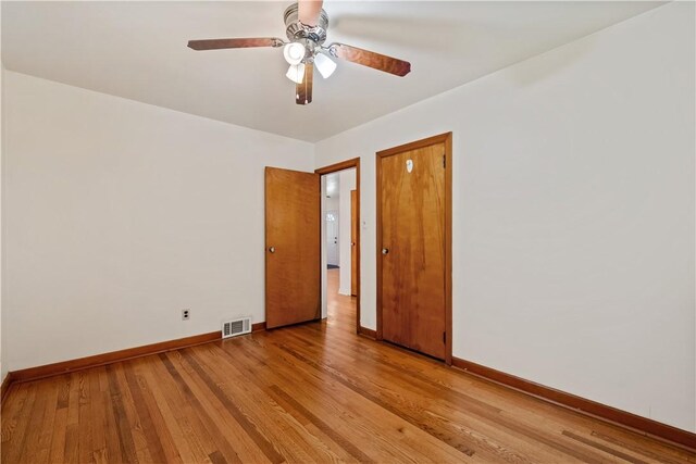 empty room with light wood finished floors, visible vents, baseboards, and ceiling fan