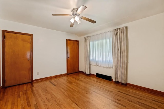 spare room featuring baseboards, a ceiling fan, and light wood-style floors