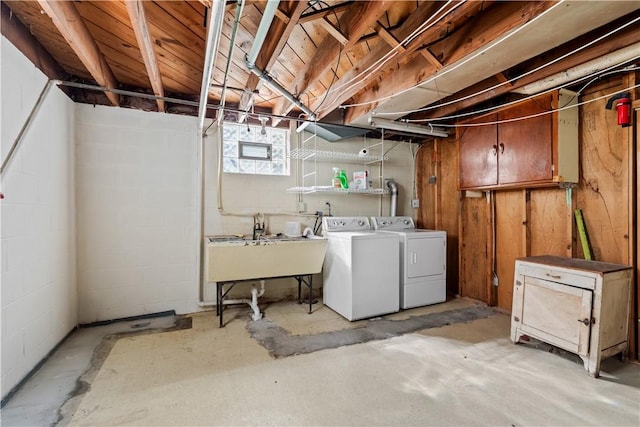 basement featuring washing machine and clothes dryer and a sink