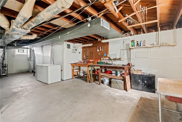 basement with fridge and a workshop area