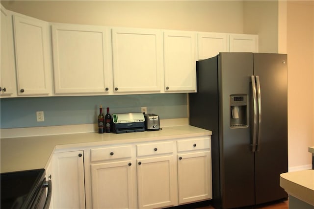 kitchen featuring white cabinetry, stainless steel fridge with ice dispenser, and light countertops
