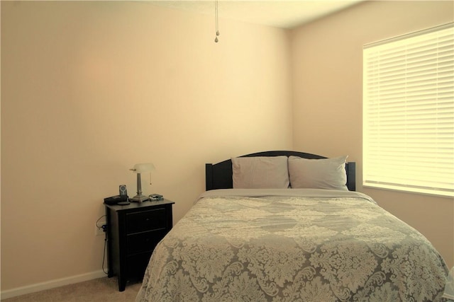 bedroom featuring light colored carpet and baseboards