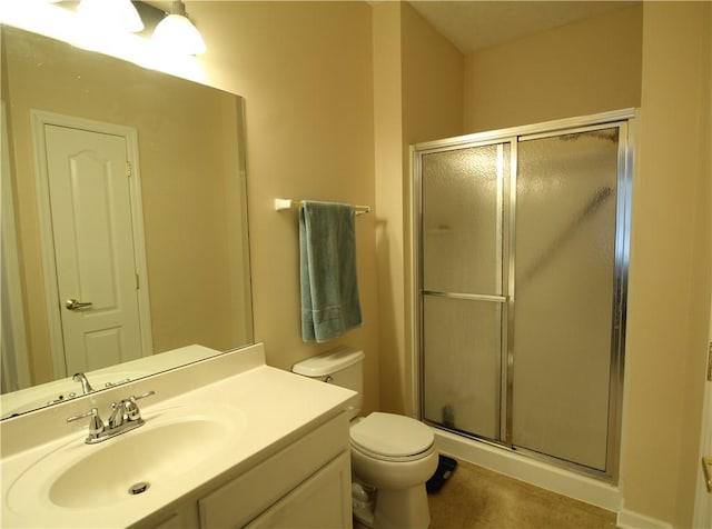 bathroom featuring tile patterned floors, vanity, toilet, and a stall shower