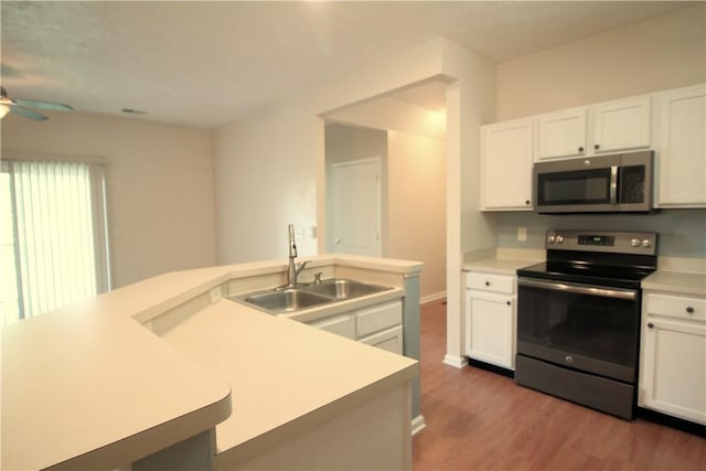 900 Hidden Ridge Ct Unit 202, South Park, PA 15129 - kitchen with stainless steel appliances, a sink, wood finished floors, ceiling fan, and white cabinetry