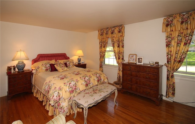 bedroom with multiple windows and wood finished floors