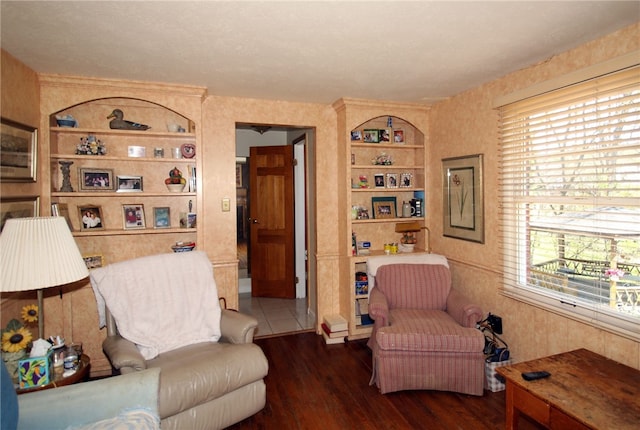 living area featuring built in features and wood finished floors