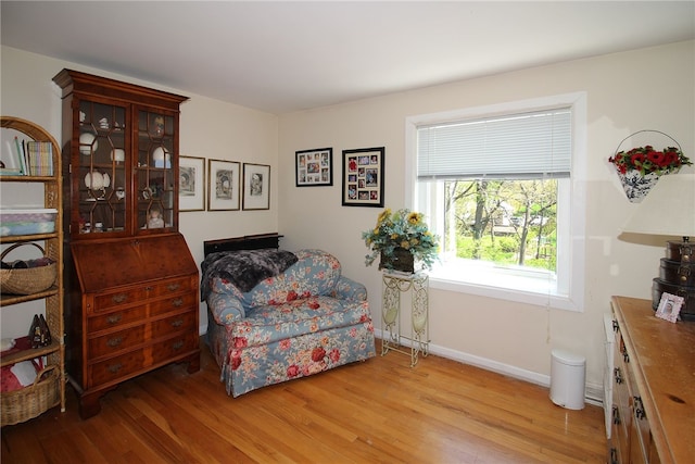 sitting room with baseboards and light wood-type flooring