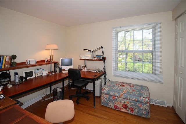 home office with baseboards, visible vents, and wood finished floors