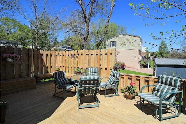 wooden deck with outdoor dining space and fence
